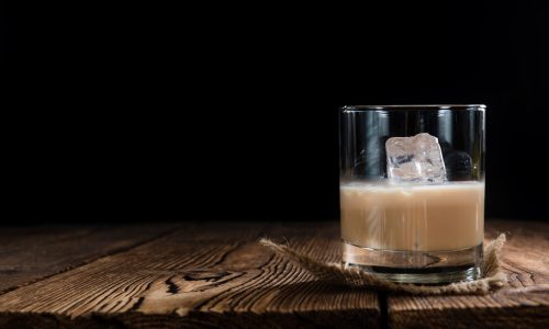 Glass with original Irish Cream Liqueuron wooden background